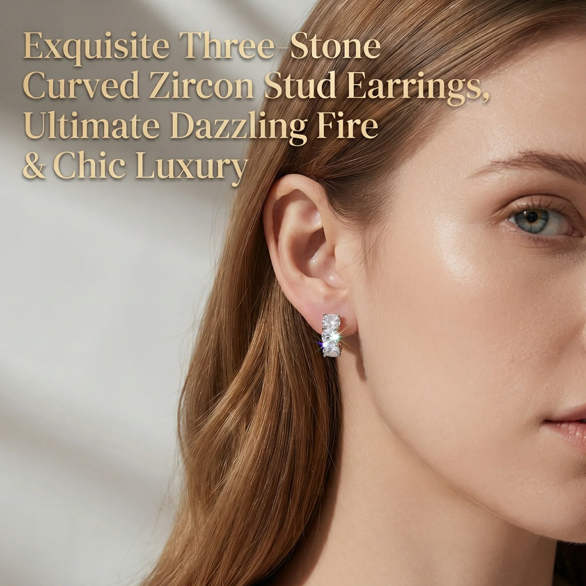 Three-stone curved stud earrings worn on the ear